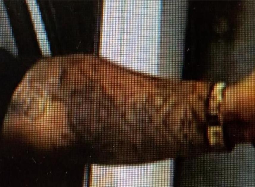 Photo of suspect's tattoos on inner right forearm with Houston Oilers logo